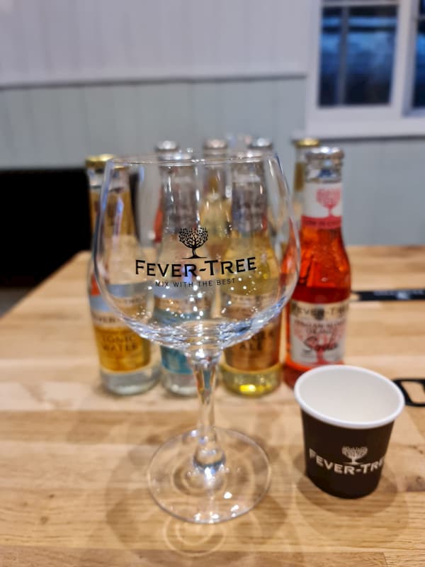 One of the special FeverTree glasses with their mixers behind