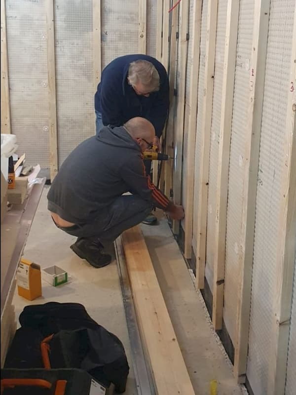 The lads putting battens in ensuring they are vertical