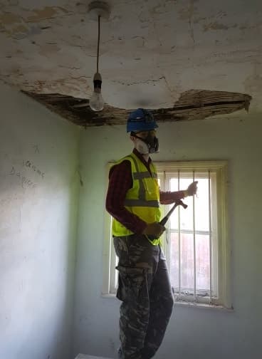 Anthony Birch pulling down the ceiling in the office