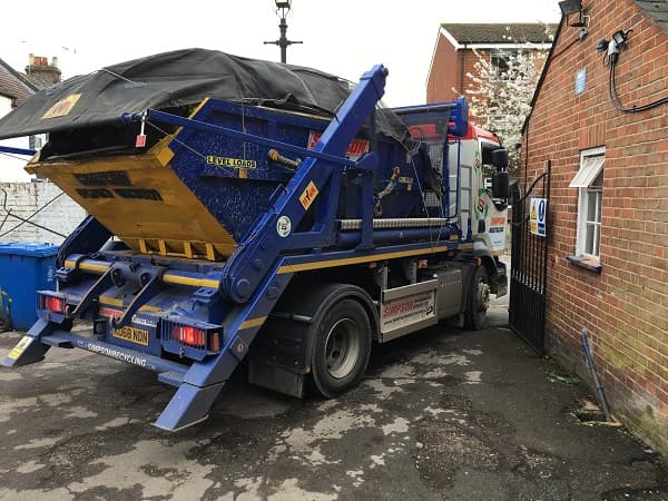 Skip lorry squeezing out of the gates