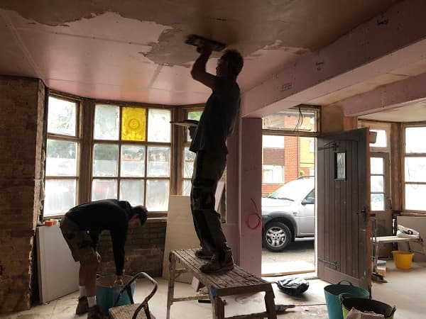 Ian plastering the ceiling on front left
