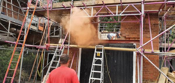 Plume of dust from bricks being cut on first floor