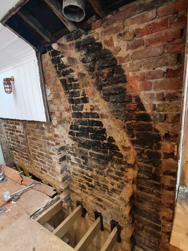 The exposed chimney breast in The School Room