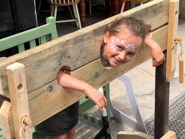 Young face-painted girl in the stocks