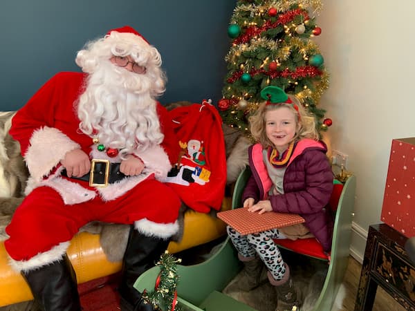 Santa meeting one of the children in his grotto