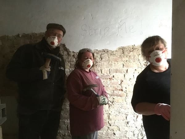 Three volunteers smiling - well presumed as wearing masks