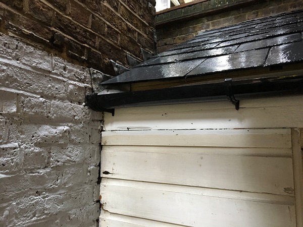 Black plastic guttering added above the door