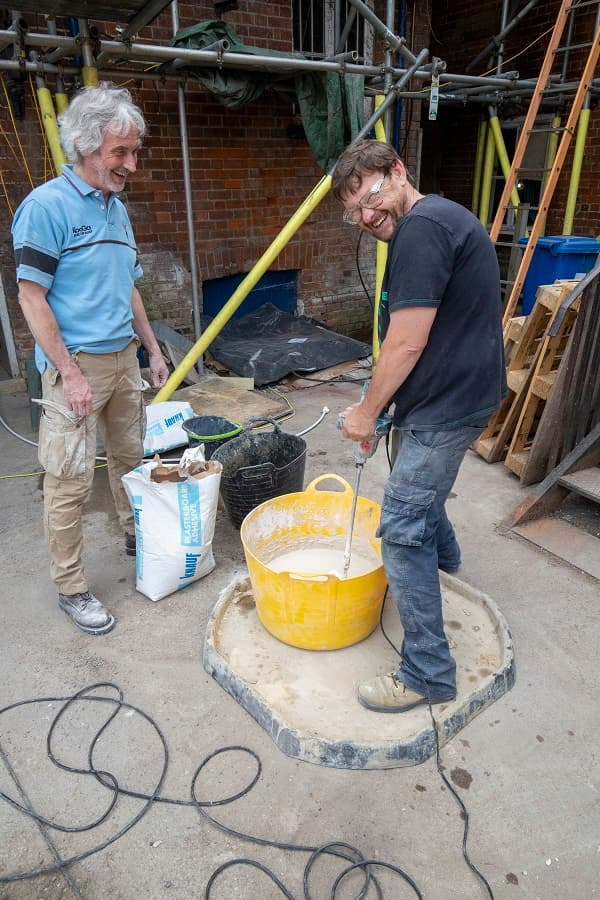 Ian and Tony mixing adhesive in the courtyard