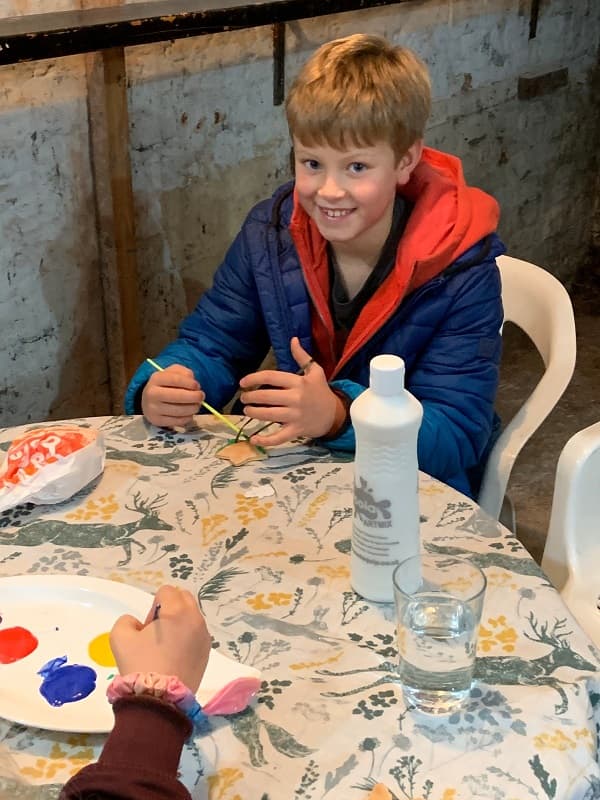 A boy painting some decorations