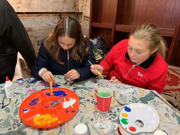 Two young girls painting some decorations