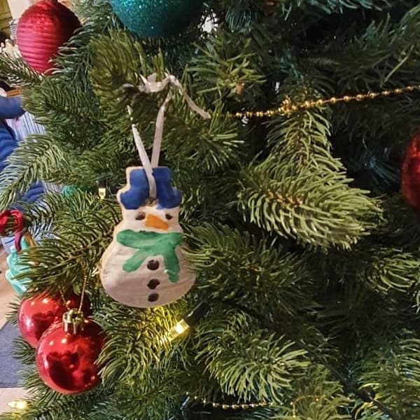 A painted snowman hanging on the tree