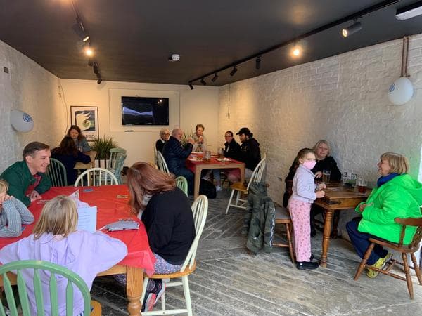 People sitting in the window enjoying the cofee and cake