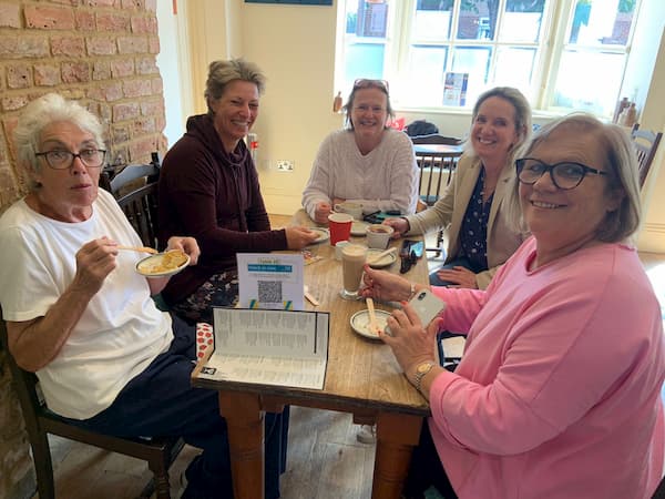 Group of ladies inside enjoying the coffee and cake