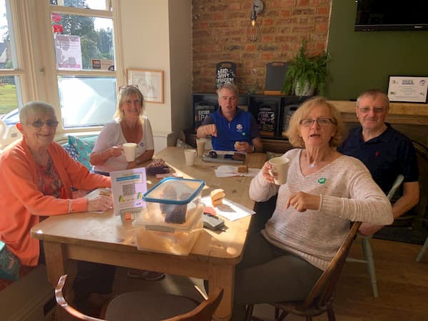 Inside one of the larger tables by the window, group of five