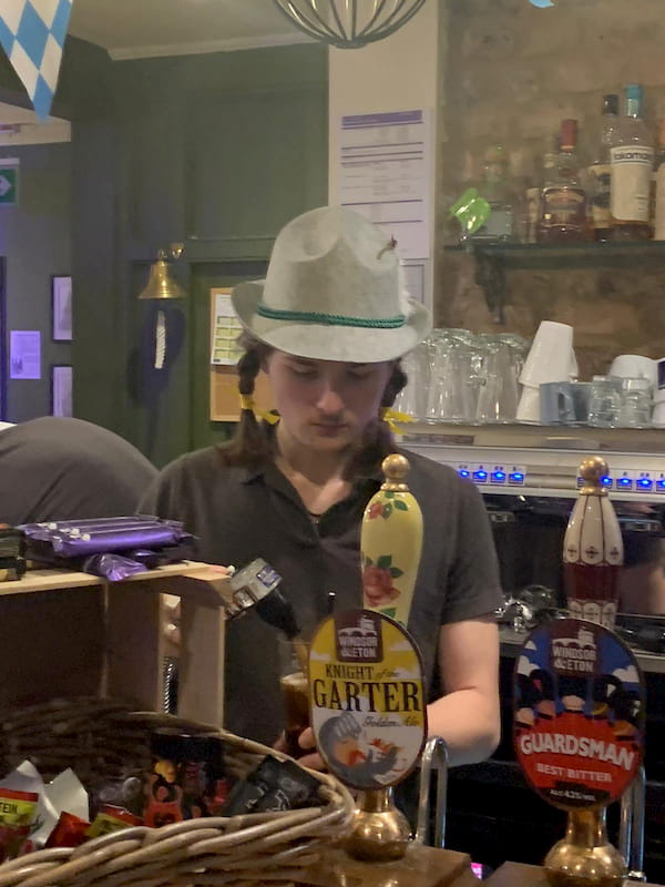 Giacomo puring a pint - plaited hair and traditional hat