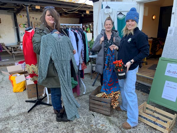 The girls setting up the pre-owned clothes stall