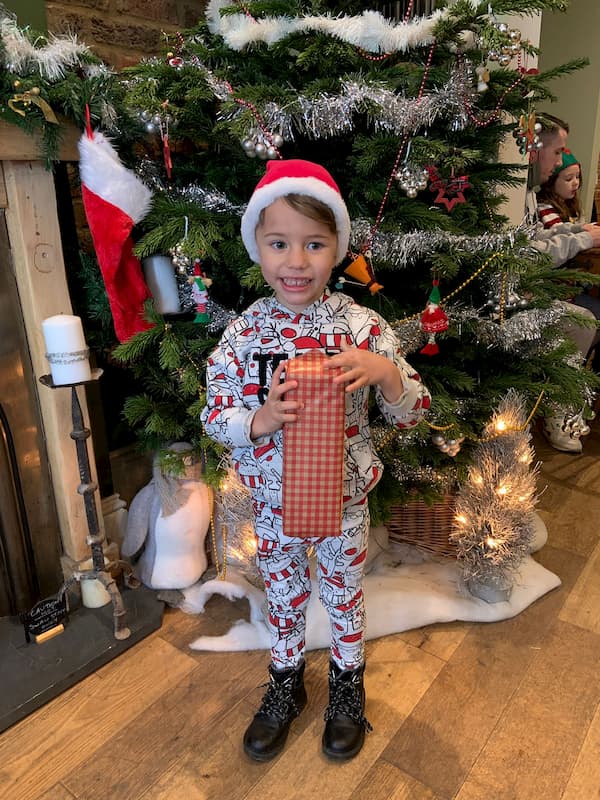 Little girl with present in front of the Christmas tree