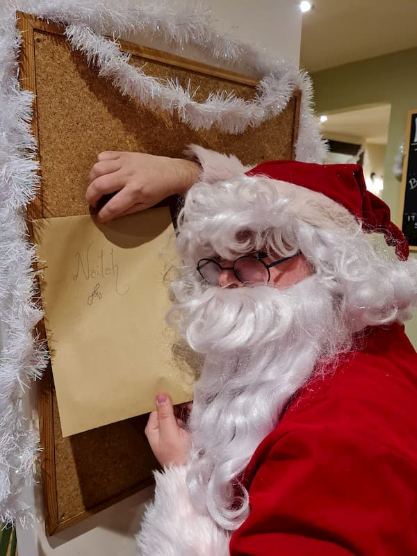 Santa pinning up his letter for one of the children