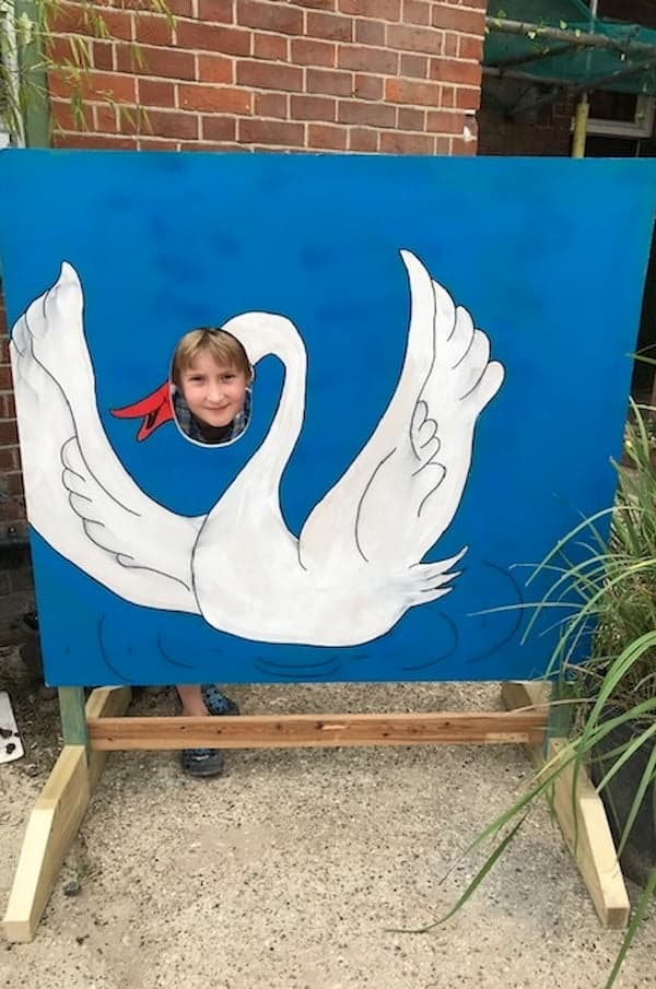 Young lad poking his head through the swan photo opportunity