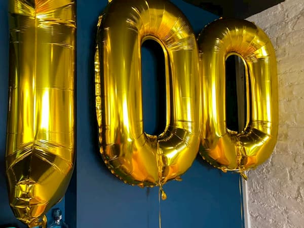 100 in golden balloons