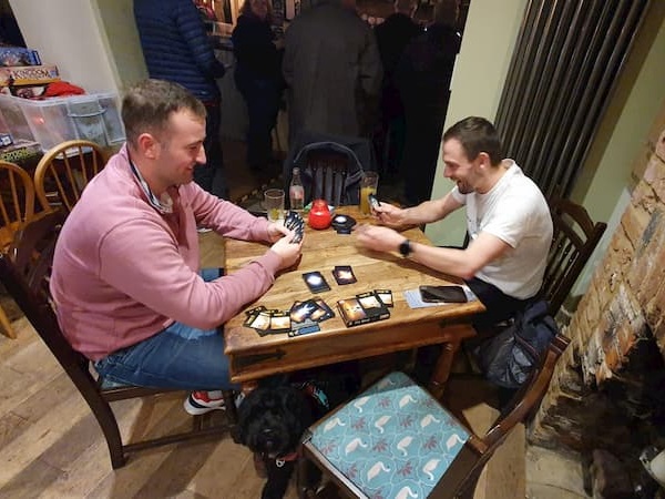 Two gents playing a card game, and not a diamond or spade in sight.