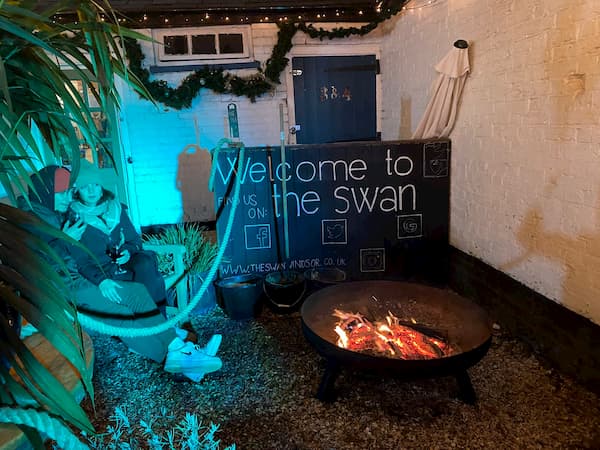 Welcome to The Swan sign with firepit for keeping warm.