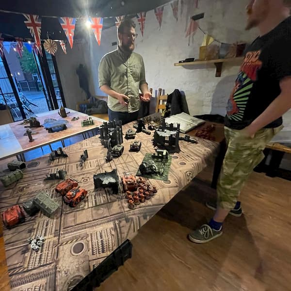 Figures laid out on the table, the guys discussing the scenario to be played.