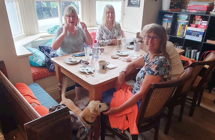 Table of ladies, and a nice dog, enjoying the Coffee Morning.