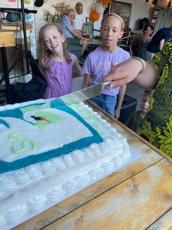 The birthday cake being cut.