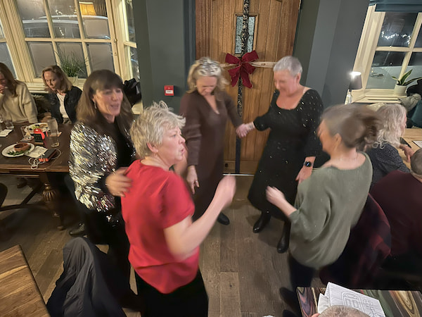 Traditional ladies dancing around the handbags