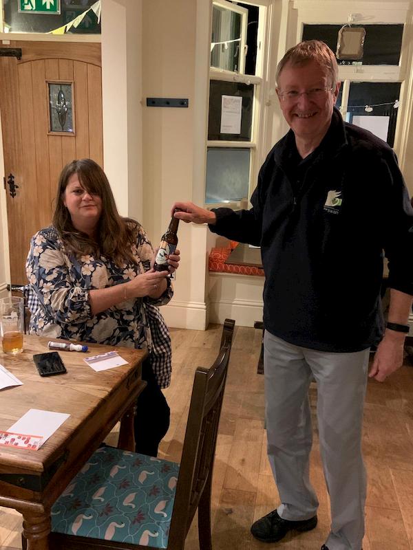 Louise receiving a bottle of beer