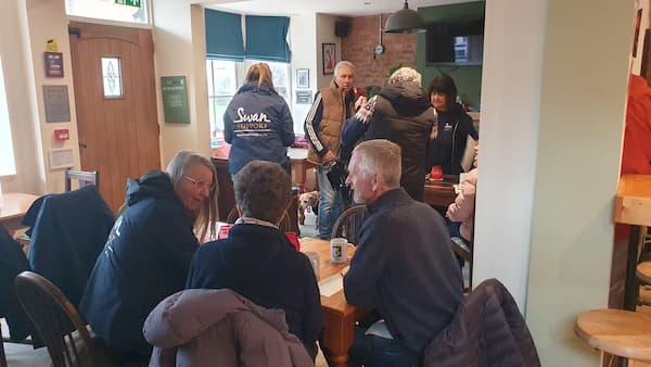 A busy pub with people, some regulars, some new.