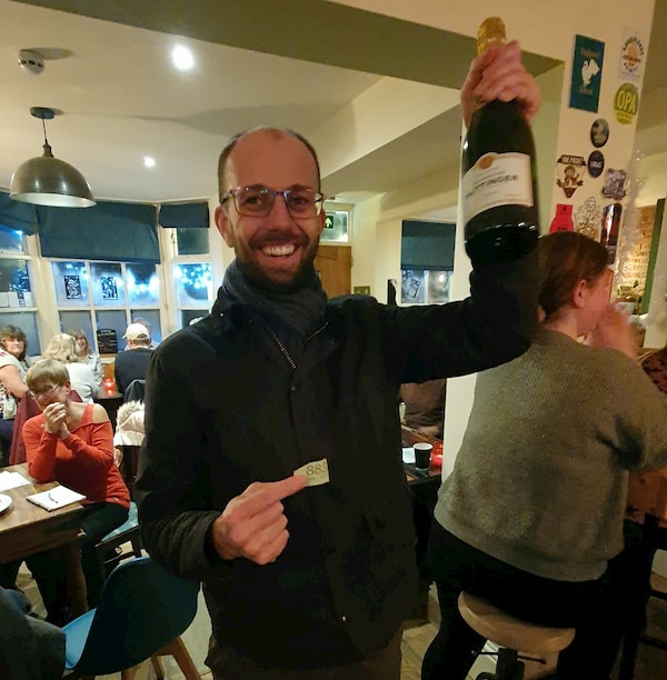 Andrew won the raffle and received a bottle of champagne.