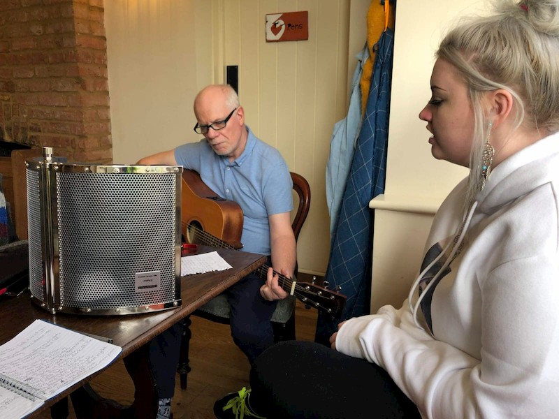 Swan Elder helping a student with a musical project