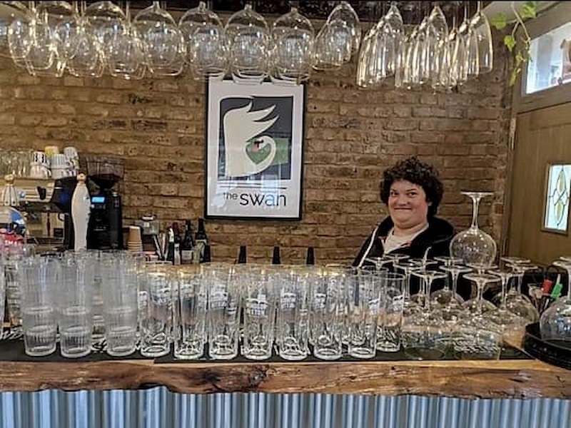 Student cleaning glasses at the main bar