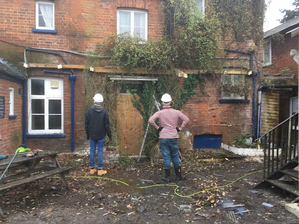 Two of the team surveying the side of the pub