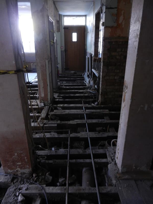 Long shot showing where bar used to be - floor boards up, rafters looking rotten