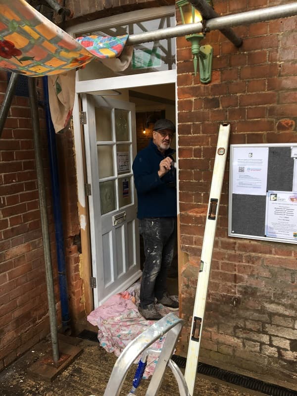 Adrian painting the door frame white