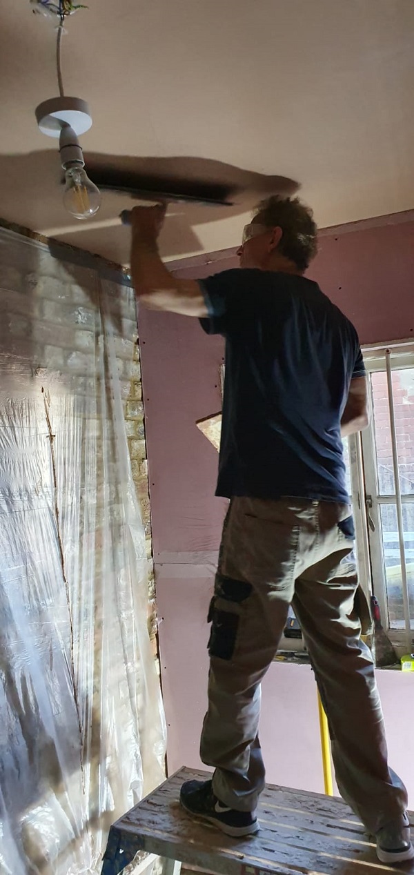 Closeup showing covered wall and ceiling plastered to the join