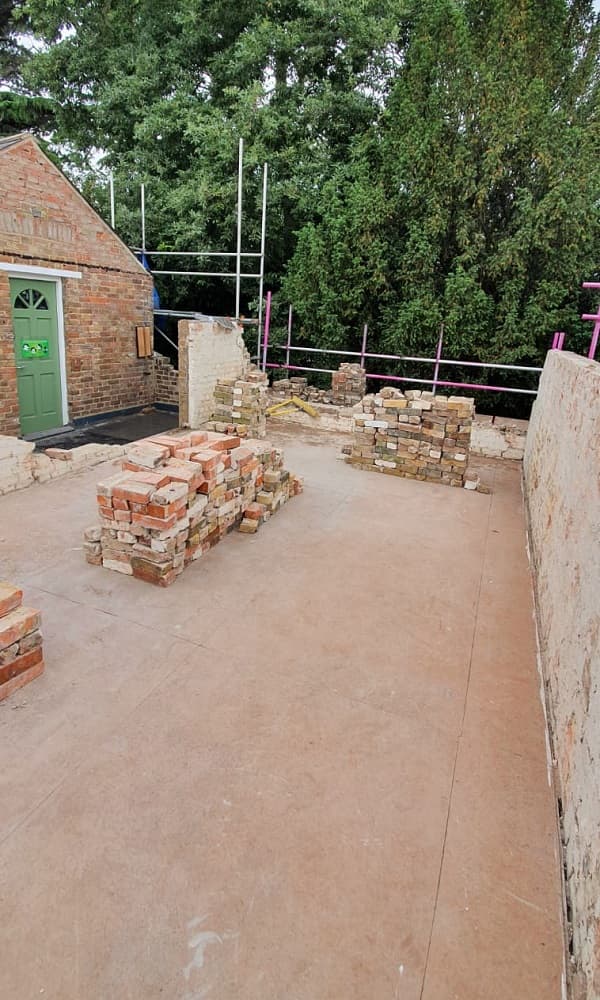 Salvageable bricks stacked on the coach house