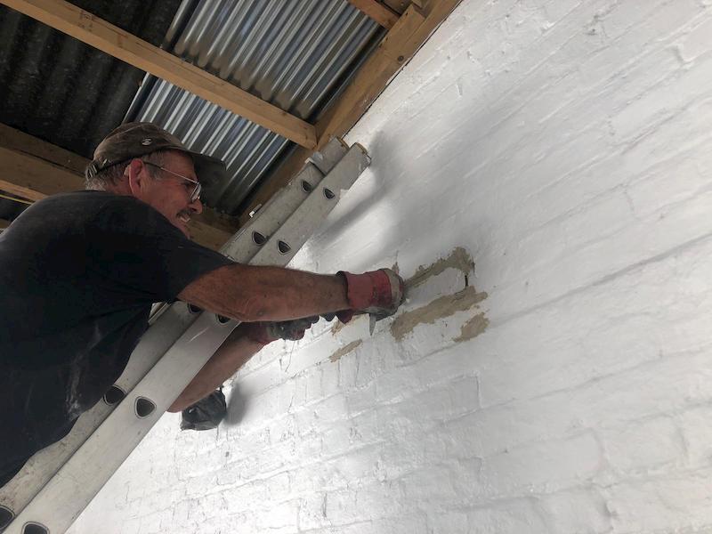 John chiseling out the old mortar on one of the chimneys