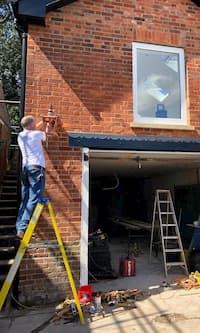 Working on the window of The Coach House