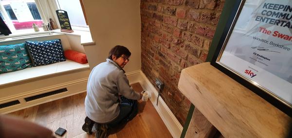 Debbie painting woodwork near the bay windows