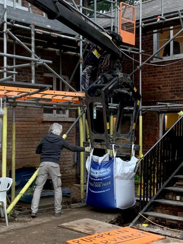 Delivry lorry dropping a bag next to The School stairs