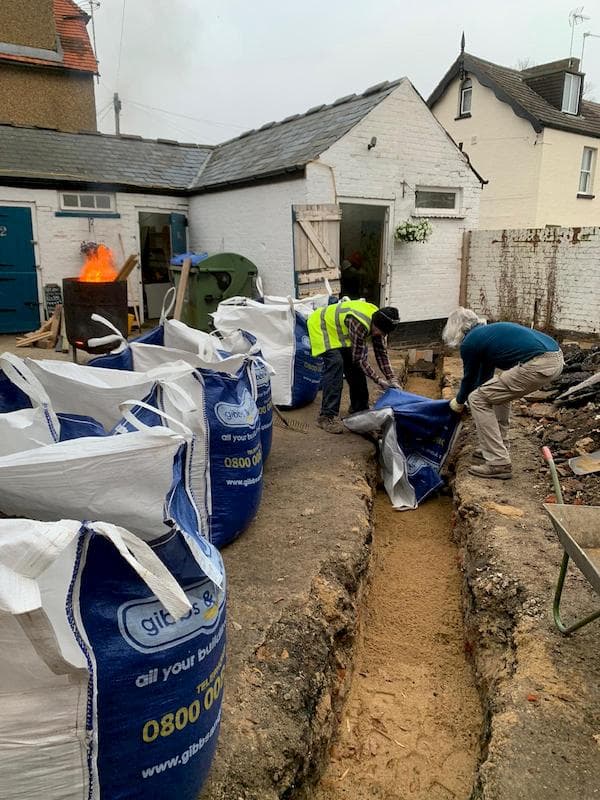 Spreading sand into the trench