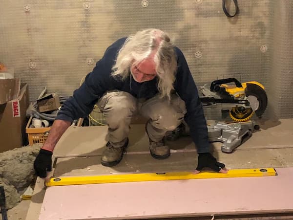 Tony measuring out a piece of plaster board