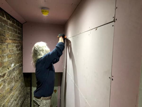 Tony fitting plasterboard in the stairs up to The School House