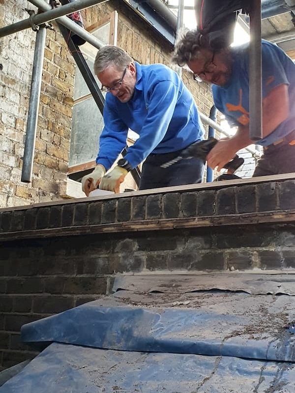 Trevor and Thomas working together to repair the roof