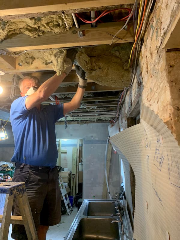 Richard stuffing insulation into the ceiling