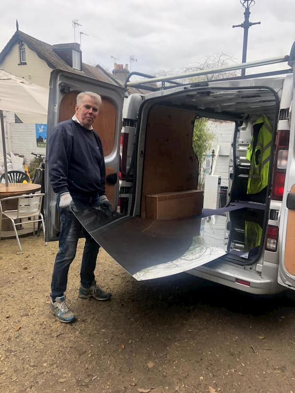 Richard Douglas taking an aluminum sheet from the back of the delivery van